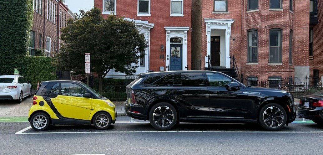 Une micro-citadine électrique garée devant un grand SUV